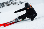 Straight on view of a man turning towards the camera with some Volkl Racetiger GS R skis on a snowy slope