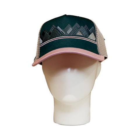 Front view of a trucker hat featuring a geometric mountain embroidery design on a dark teal front panel, with a light pink curved brim and white mesh back. The hat is displayed on a white mannequin head.