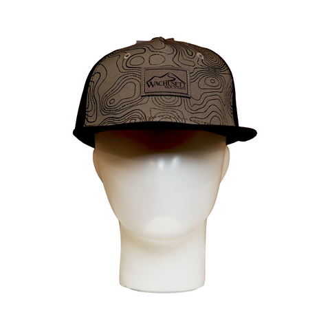 Front view of a flat brim hat with a grey crown covered in topographic map-style contour lines. The center front displays a rectangular patch with the "Wachusett Mountain" logo. The brim is flat and black, and the hat is shown on a white mannequin head.